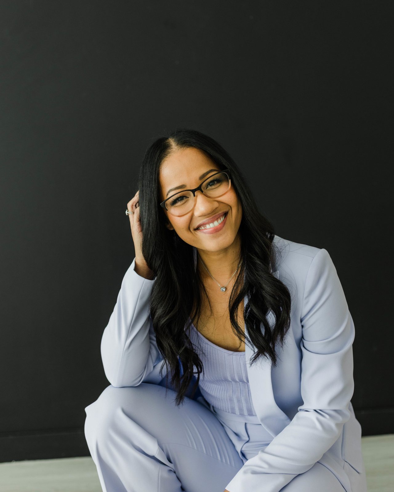 Dr. Sheena Glover smiling, photographed against a dark backdrop